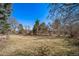 Expansive grassy backyard lined with mature trees, providing serene outdoor space at 5404 W Rowland Pl, Littleton, CO 80128
