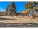 Brick home with a large tiered deck overlooks expansive grassy backyard at 5404 W Rowland Pl, Littleton, CO 80128