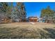 Large grassy backyard with brick home, tiered deck, mature trees and a playground at 5404 W Rowland Pl, Littleton, CO 80128