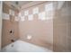 Neutral-toned bathroom features tiled walls and a shower-tub combination at 5404 W Rowland Pl, Littleton, CO 80128