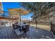 Wooden deck featuring a dining set, umbrella, and fenced perimeter at 5404 W Rowland Pl, Littleton, CO 80128