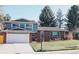 Charming two-story home featuring brick and blue siding with a well-manicured front lawn and driveway at 5404 W Rowland Pl, Littleton, CO 80128