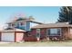 Charming two-story home featuring brick and blue siding with a well-manicured front lawn at 5404 W Rowland Pl, Littleton, CO 80128