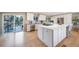 Modern kitchen featuring stainless steel appliances, white cabinets, and a large island with a countertop range at 5404 W Rowland Pl, Littleton, CO 80128