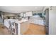 Bright kitchen features an island with seating, stainless steel appliances, and lots of cabinet space at 5404 W Rowland Pl, Littleton, CO 80128