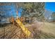 Wooden playground with slide is nestled in the backyard amongst mature trees and landscaping at 5404 W Rowland Pl, Littleton, CO 80128