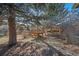 Wooden playground with slide sits under mature trees in the backyard at 5404 W Rowland Pl, Littleton, CO 80128