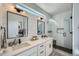 Modern bathroom featuring dual sinks, sleek fixtures, and a glass-enclosed shower with tiled walls at 1301 Osceola St, Denver, CO 80204