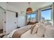 Bright bedroom with large windows, closet doors, television and a comfortable bed with neutral bedding at 1301 Osceola St, Denver, CO 80204