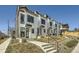 Modern townhomes with white siding, black trim, and small front yards offer contemporary living in a vibrant community at 1301 Osceola St, Denver, CO 80204