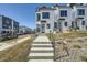 Contemporary townhome boasts a clean white facade, black framed windows, and a concrete path leading to the front entrance at 1301 Osceola St, Denver, CO 80204