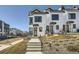 Modern townhome exterior featuring white siding, black trim, and a welcoming front entrance with a concrete walkway at 1301 Osceola St, Denver, CO 80204