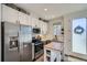 Bright kitchen with stainless steel appliances, white cabinets, and a functional island offering both style and practicality at 1301 Osceola St, Denver, CO 80204