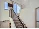 Interior staircase with modern railing leading to an upper level with a window and seating area at 1301 Osceola St, Denver, CO 80204