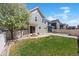 A well-maintained backyard with a small stone patio area and flourishing tree in a suburban neighborhood at 9472 E 109Th Pl, Commerce City, CO 80640