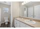 Bathroom featuring double sinks, a large mirror, and an adjacent toilet and shower area at 9472 E 109Th Pl, Commerce City, CO 80640