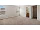 Bedroom features neutral carpet, white walls and trim, and a doorway to an en-suite bathroom at 9472 E 109Th Pl, Commerce City, CO 80640