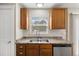 Close up of kitchen with wood cabinets, stainless steel appliances, and a window above the sink at 9472 E 109Th Pl, Commerce City, CO 80640