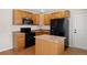 Efficient kitchen with wood cabinets and black appliances offers a functional layout at 9472 E 109Th Pl, Commerce City, CO 80640