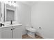 A simple bathroom features a white toilet and vanity with a mirror above it, and hardwood-style floors at 1347 S Crystal Way, Aurora, CO 80012