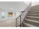A well-lit staircase with carpeted steps leads up from the hardwood-style floor in the living room at 1347 S Crystal Way, Aurora, CO 80012