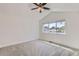Bright bedroom featuring neutral carpeting, white walls, a ceiling fan, and a view of the neighborhood at 3640 Lipan St, Denver, CO 80211