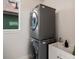 Modern laundry room with stacked washer and dryer, a utility sink, and a bright window at 3640 Lipan St, Denver, CO 80211