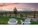 Beautiful backyard featuring Adirondack chairs facing an expansive yard with a charming fence and mountain views at 1601 Mariah Ln, Erie, CO 80516