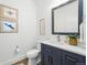 Stylish half bathroom with a blue vanity, white marble countertop, and framed art prints at 1601 Mariah Ln, Erie, CO 80516