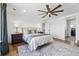 Large bedroom with a ceiling fan, hardwood floors, and plush bed, offering a comfortable retreat at 1601 Mariah Ln, Erie, CO 80516