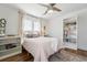 Bright bedroom with hardwood floors, ceiling fan, built-in bookshelves, and light pink bedding at 1601 Mariah Ln, Erie, CO 80516
