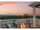 Relaxing deck view complete with a fire pit, comfortable seating, and stunning sunset scenery at 1601 Mariah Ln, Erie, CO 80516