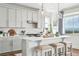 Stylish kitchen with white cabinets, marble backsplash, and an island with seating for three at 1601 Mariah Ln, Erie, CO 80516