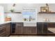 Modern kitchen with dark wood cabinets, wine fridge, farmhouse sink, and marble tile backsplash at 1601 Mariah Ln, Erie, CO 80516