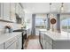 Modern kitchen with gray cabinets, stainless steel appliances, and a large island with seating at 1601 Mariah Ln, Erie, CO 80516