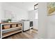 Bright laundry room with modern washer and dryer, wooden shelf, artwork, and wood floors at 1601 Mariah Ln, Erie, CO 80516