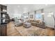 Open-concept living area with a sectional sofa, large windows, and hardwood floors, creating a cozy space at 1601 Mariah Ln, Erie, CO 80516