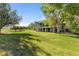 Well-maintained backyard featuring a spacious lawn, mature trees, and a charming two-story home at 15132 Pecos St, Broomfield, CO 80023
