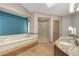 Bright bathroom featuring a soaking tub with a blue accent wall and a granite countertop vanity with dual sinks at 15132 Pecos St, Broomfield, CO 80023