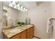 Bathroom featuring double sinks with granite countertops, wood cabinets, and a large mirror at 15132 Pecos St, Broomfield, CO 80023