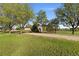 Manicured front lawn with mature trees, a gravel driveway, and a charming home at 15132 Pecos St, Broomfield, CO 80023