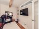Cozy bedroom with hardwood floors, a large TV, and convenient storage shelves at 2460 W Caithness Pl # 105, Denver, CO 80211