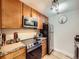 Kitchen with stainless steel appliances, wooden cabinets, and granite countertops at 2460 W Caithness Pl # 105, Denver, CO 80211