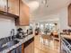 Bright kitchen with granite counters, wood cabinets, and an open view into the living area at 2460 W Caithness Pl # 105, Denver, CO 80211