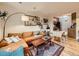Inviting living room with a comfortable orange sofa, stylish rug, and access to the kitchen at 2460 W Caithness Pl # 105, Denver, CO 80211