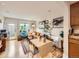 Open-concept living area with hardwood floors, a kitchen, dining table, and cozy seating by the window at 2460 W Caithness Pl # 105, Denver, CO 80211