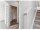 Hallway view with stairs and an open door leading to a full bathroom with tub and shower at 453 Interlocken Blvd # 101, Broomfield, CO 80021