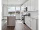 Modern white kitchen with stainless steel appliances, large window and center island at 453 Interlocken Blvd # 101, Broomfield, CO 80021