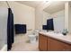 Functional bathroom with vanity sink, tiled floor, shower-tub combination with navy shower curtain at 7212 S Blackhawk St # 1-103, Englewood, CO 80112