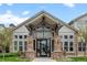 Daytime view of the building entrance featuring stone pillars, many windows, and peaked roof design at 7212 S Blackhawk St # 1-103, Englewood, CO 80112
